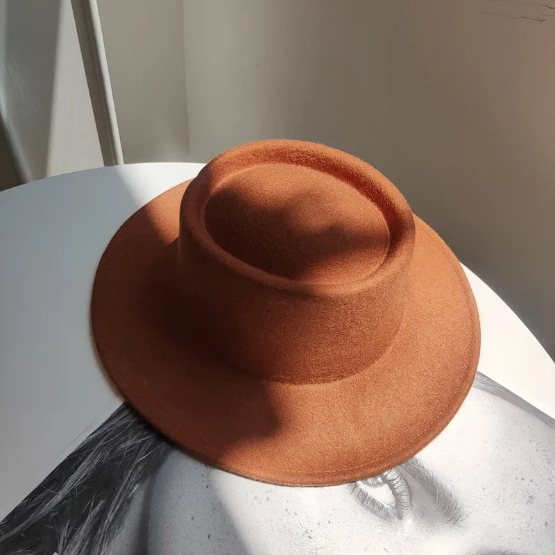 Brown hat on a white surface with a neutral background