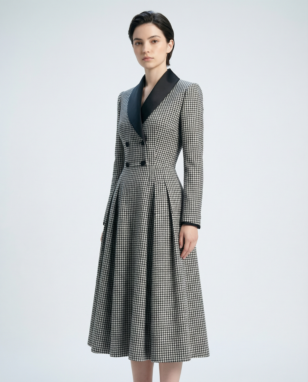 Woman wearing a checkered coat with a black collar on a light gray background