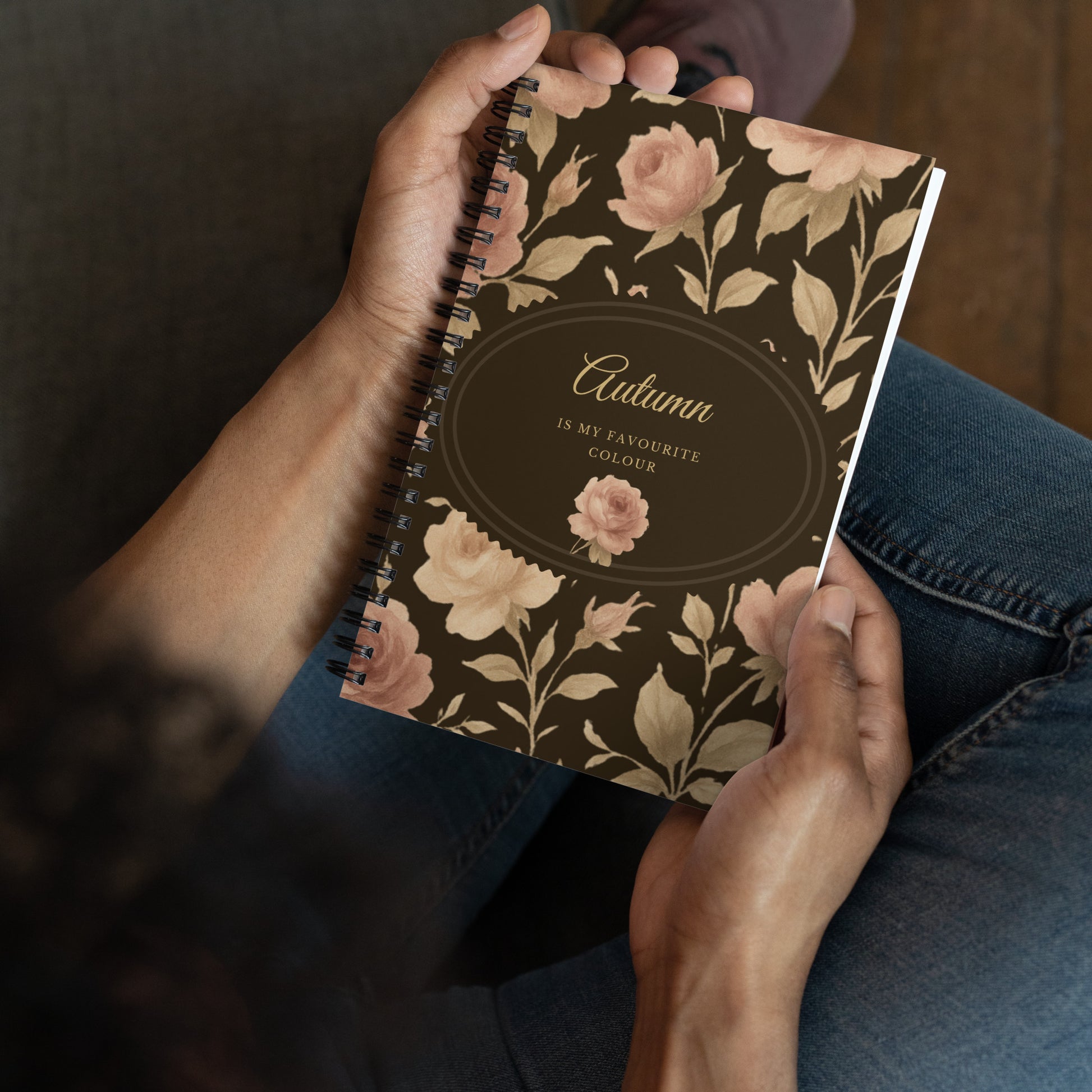Person holding a notebook with floral design and text