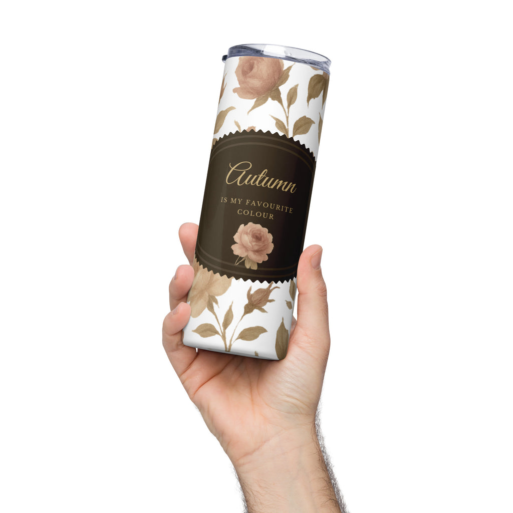 Tumbler with floral design and 'Autumn is my favourite colour' text held by a hand on a white background
