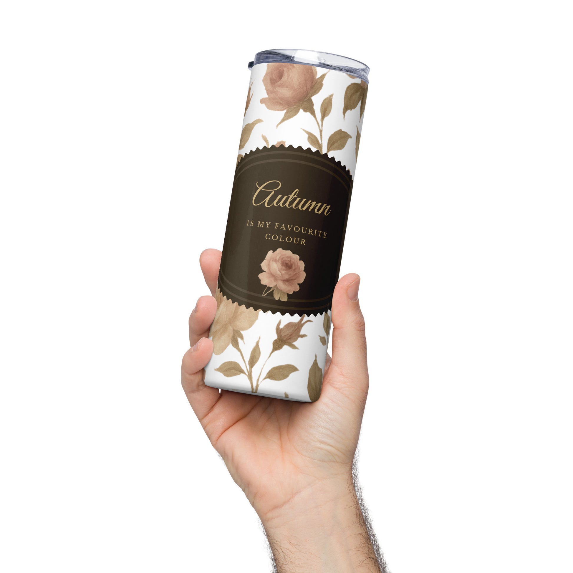 Tumbler with floral design and 'Autumn is my favourite colour' text held by a hand on a white background